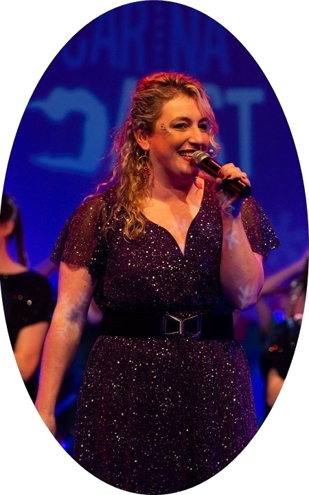 Tina Brouwers zingt op het podium in een glinsterende jurk